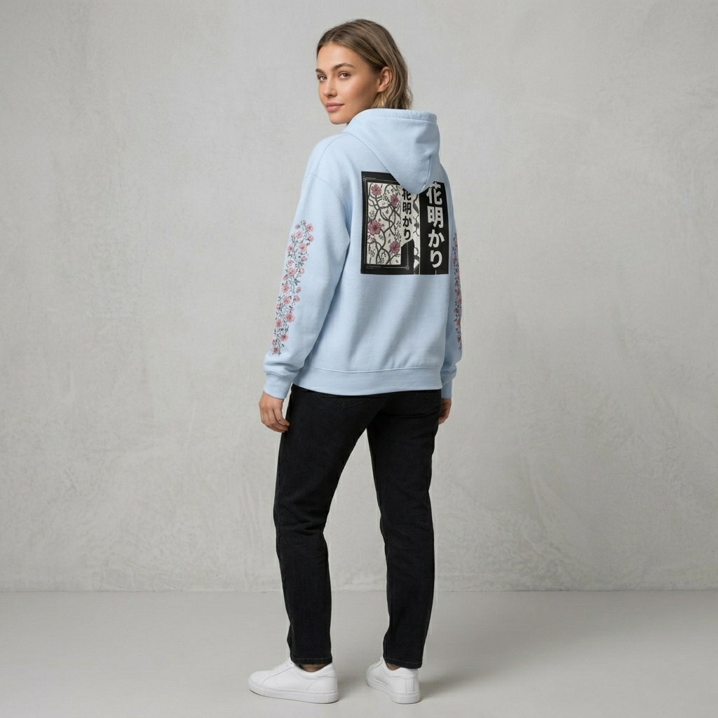 Person wearing a light blue hoodie with floral designs on a plain background